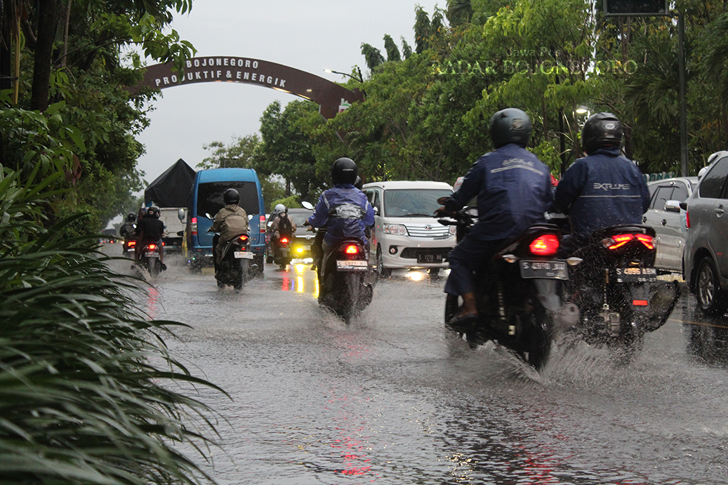 TERGENANG: Jalan Gajah Mada Bojonegoro ini tergenang saat hujan kemarin.  Kondisi ini masih kerap terjadi di musim hujan. Butuh solusi dari instansi terkait. (DHANI WAHYU ALFIANSYAH/RADAR BOJONEGORO)