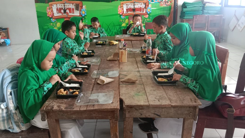 UJI COBA: Siswa sedang mendapat makan gratis sebagai uji coba realisasi program janji kampanye presiden dan wakil persiden terpilih. (DEWI SAFITRI/RADAR BOJONEGORO)
