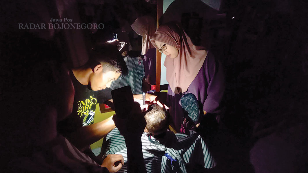 LANGGANAN PADAM: Warga sedang potong rambut, mendadak listriknya padam tanpa pemberitahuan dari PLN. (DEWI SAFITRI/RADAR BOJONEGORO)