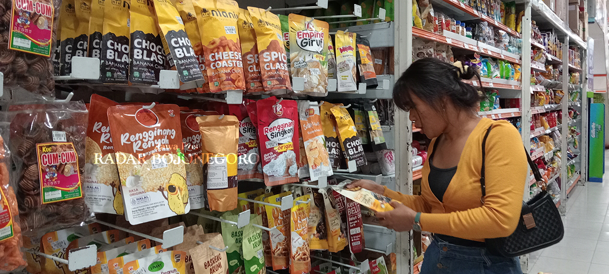 PRODUK UMKM: Seorang pembeli sedang memilih aneka camilan produk UMKM yang dijual di salah supermarket Bojonegoro.  (YANA DWI KURNIYA WATI/RADAR BOJONEGORO)