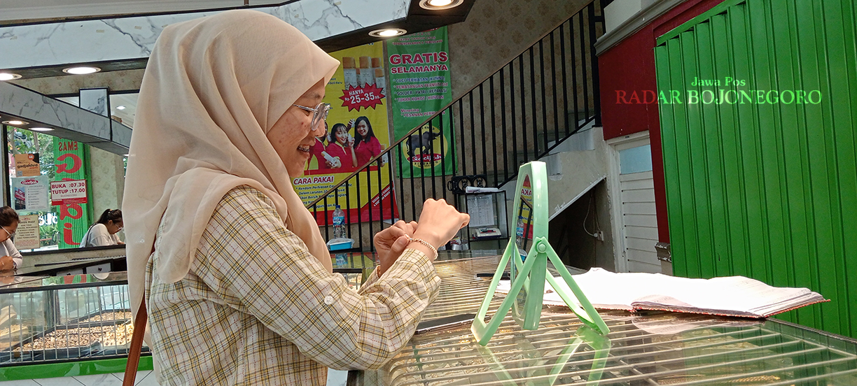 DICOBA DULU: Konsumen salah satu toko emas sedang mencoba perhiasan emas, harga di awal tahun ini relatif stabil. (YANA DWI KURNIYA WATI/RADAR BOJONEGORO)