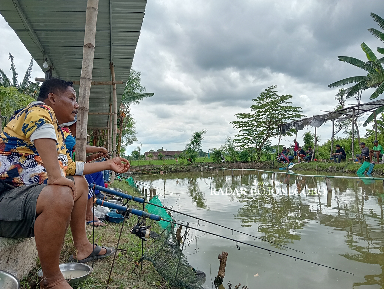 FOKUS: Para peserta kompetisi memancing di Desa Deru, Kecamatan Sumberrejo fokus pada masing-masing joran, menunggu umpannya disambar ikan. (YANA DWI KURNIYA WATI/RADAR BOJONEGORO)