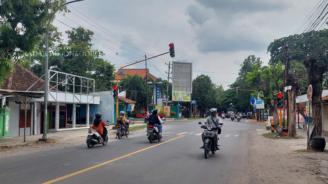 USAI BENTROK: Traffic light perempatan Karangjati tampak ramai lancar kemarin (15/1). Diketahui jalan tersebut jadi saksi bisu bentrok berdarah, Selasa (14/1). (M. LUKMAN HAKIM/RADAR BOJONEGORO)