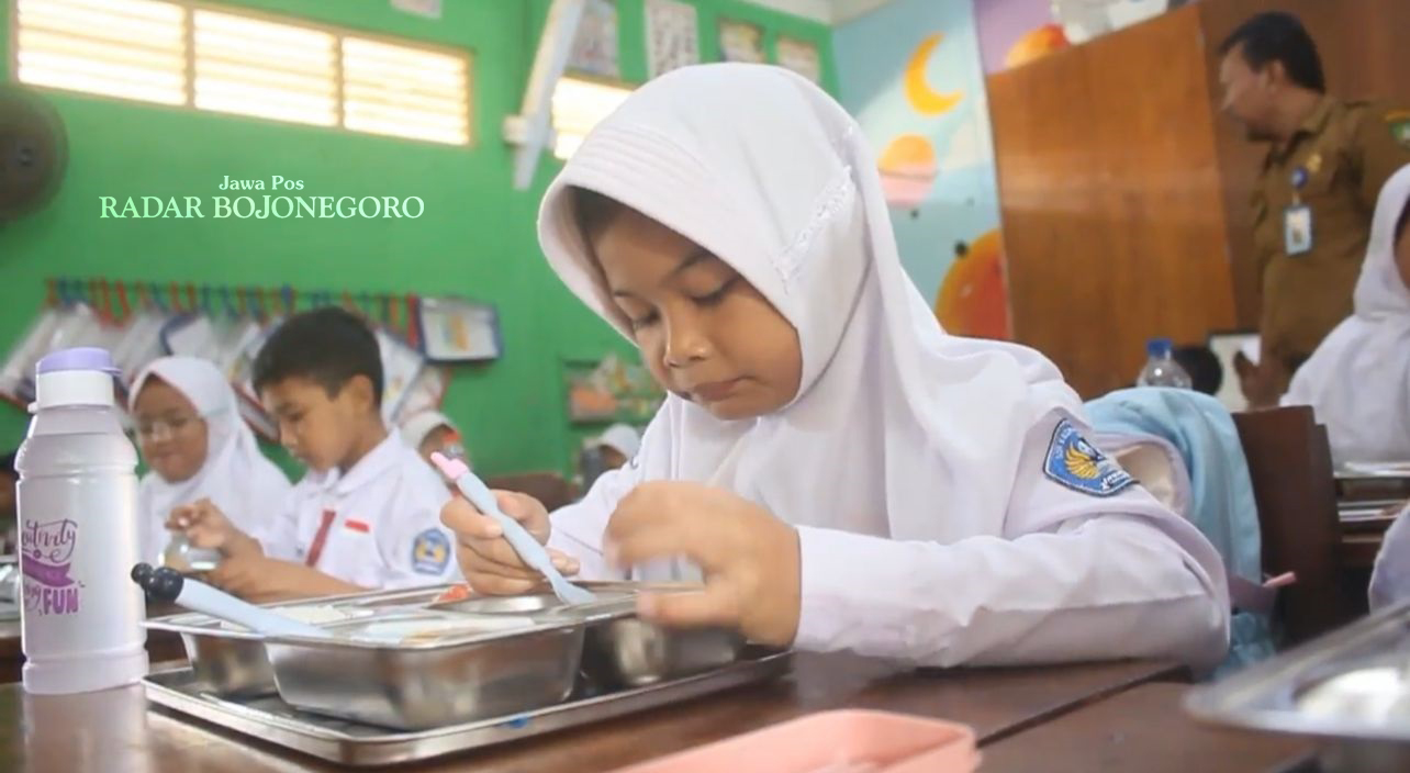 MAKAN BERGIZI: Siswa-siswi SDN Kedungjenar sedang lahap menyantap makan bergizi grati yang dihidangkan menggunakan ompreng. (RAHUL OSCARRA DUTA/RADAR BOJONEGORO)