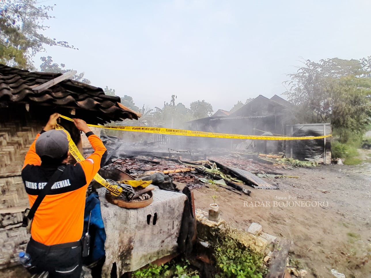 LUDES TERBAKAR: Petugas memasang garis polisi di lokasi kebakaran turut Dukuh Nglebok, Kelurahan Tambakromo, Kecamatan Cepu kemarin (24/1). (ISTIMEWA/RADAR BOJONEGORO)