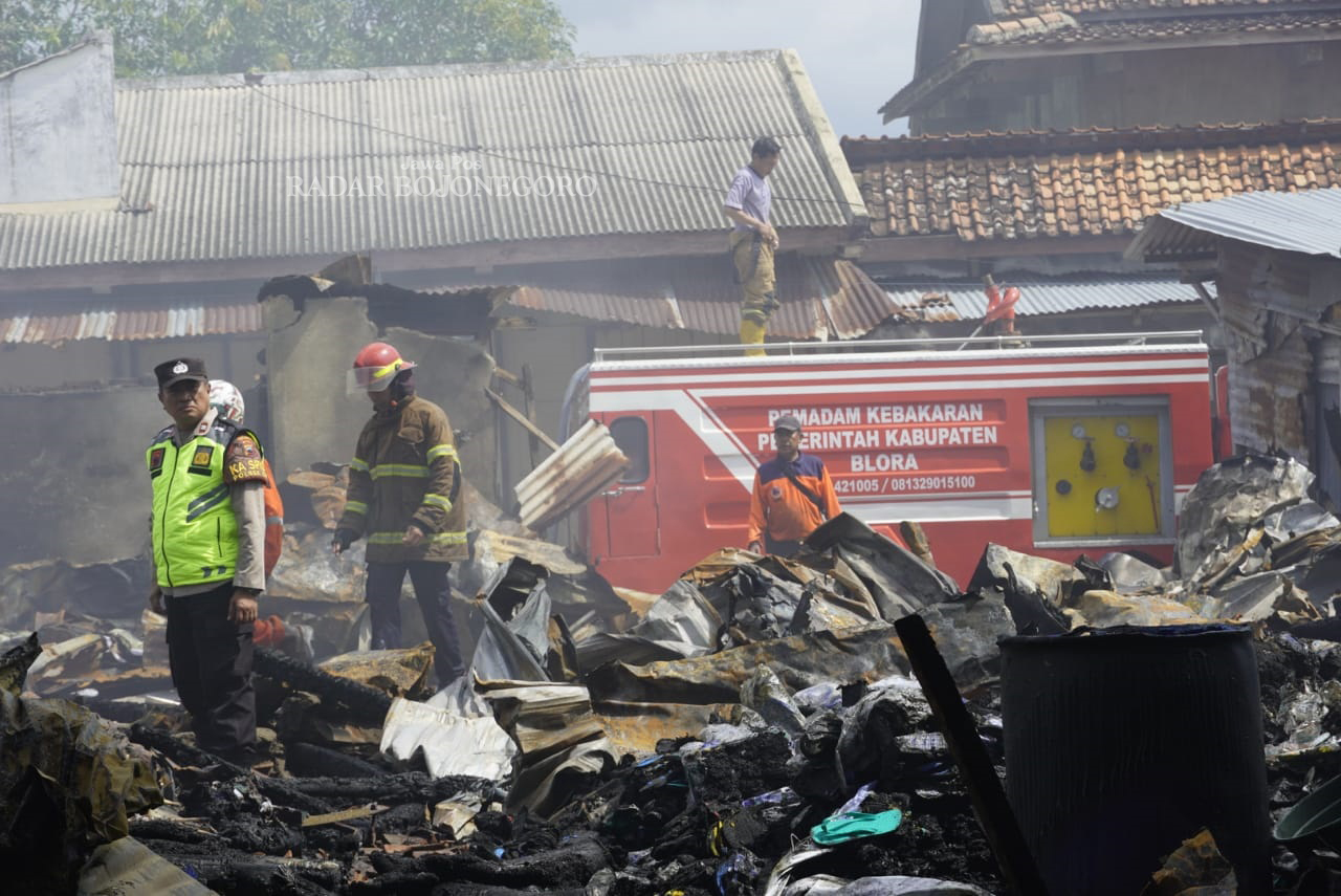 PEMADAMAN: Petugas damkar beserta polisi berjibaku memadamkan kebakaran kios Pasar Induk Cepu, Minggu pagi lalu (26/1). (ISTIMEWA/RADAR BOJONEGORO)