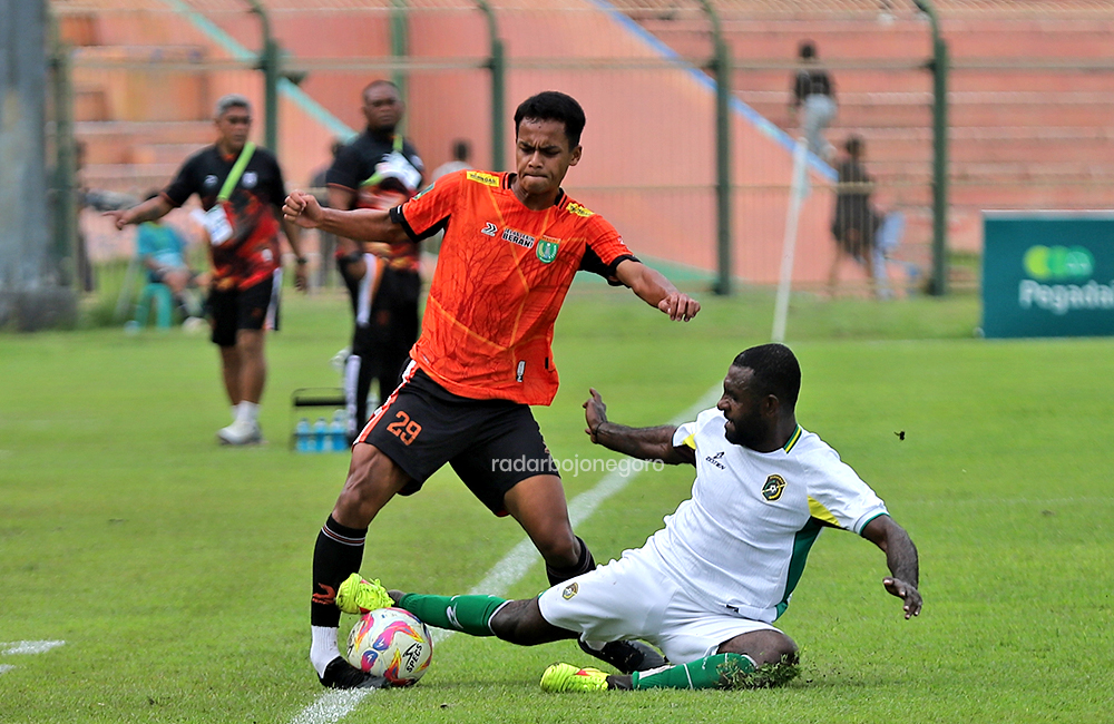 TEPI LAPANGAN: Pemain tengah Persibo Ardi Maulanan mempertahankan bola di tepi lapangan saat ditekel bek Persewar Yanto Basna pada laga playoff degradasi Liga 2 di Stadion Letjen Sudirman (SLS).