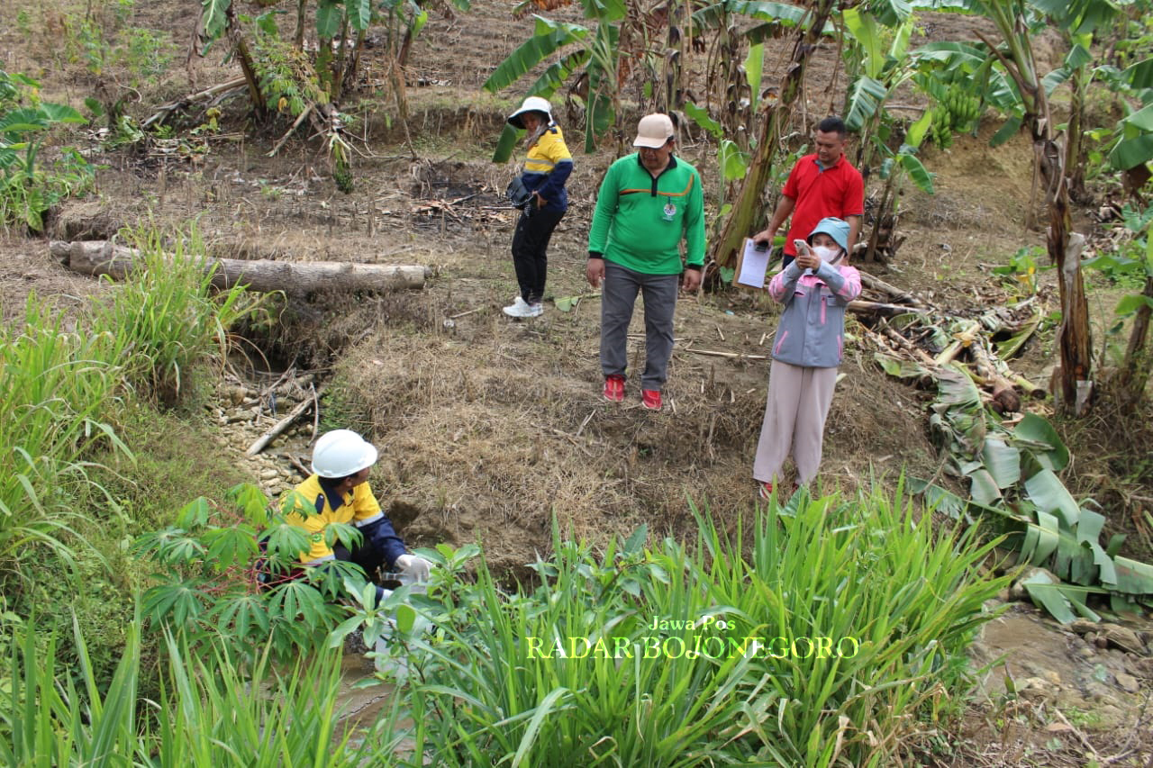 TERCEMAR: Petugas sedang mendalami dugaan pencemaran sungai dari semburan minyak bumi. (LUKMAN HAKIM/RADAR BOJONEGORO)