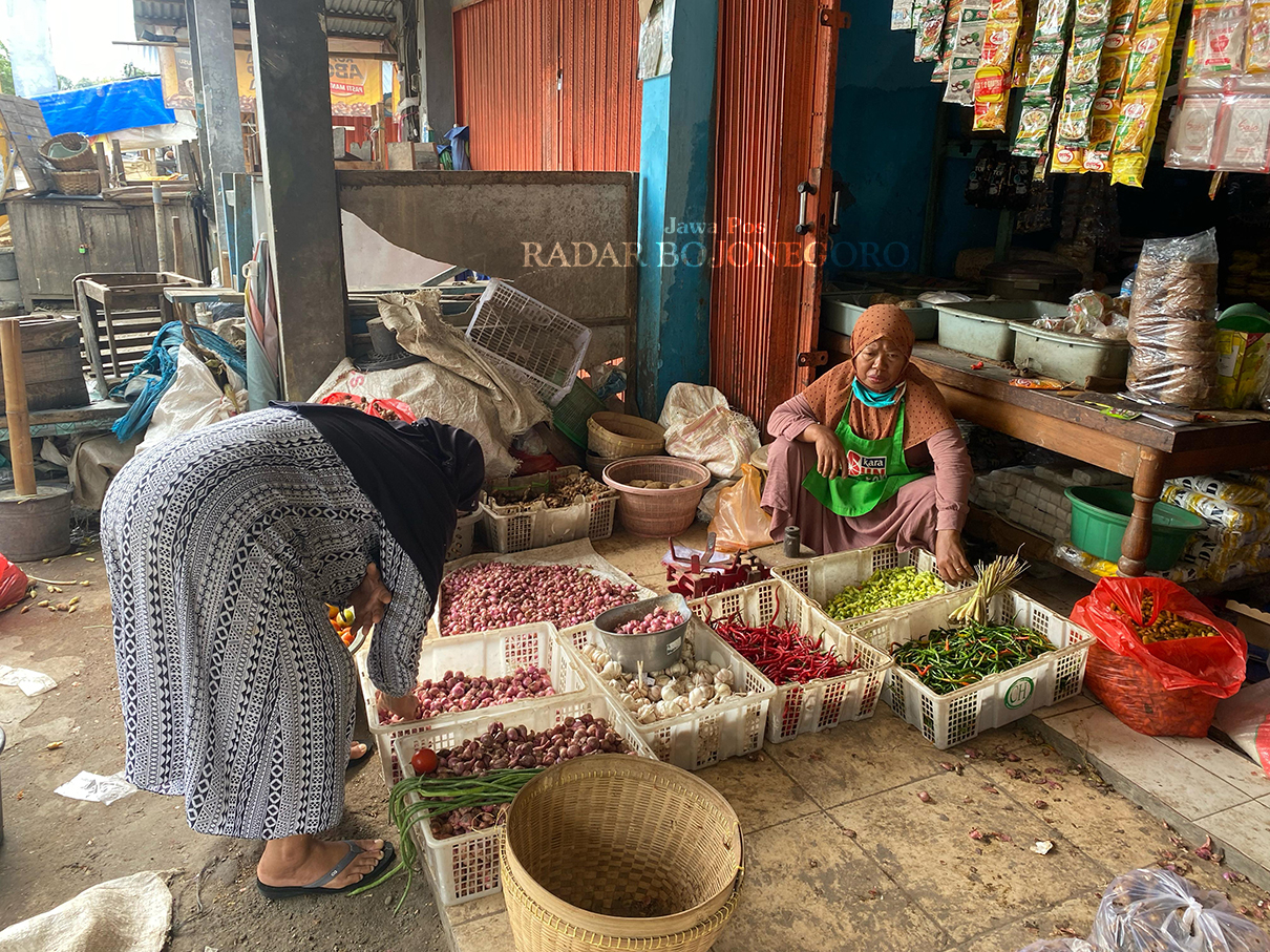 PEDAGANG: Aktivitas jual beli berlangsung di Pasar Jepon, tampak pedagang melayani pembelian sayur dan bahan pokok. (M. LUKMAN HAKIM/RADAR BOJONEGORO)