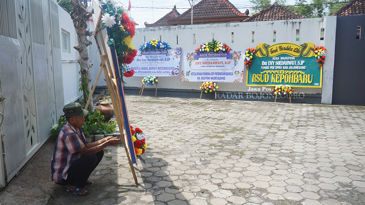 RUMAH DUKA: Karangan bunga untuk almarhumah Eny Soedarwati tertata rapi di halaman rumah duka turut Desa Sobontoro, Kecamatan Balen kemarin (21/3). (YUAN EDO RAMADHANA/RADAR BOJONEGORO)