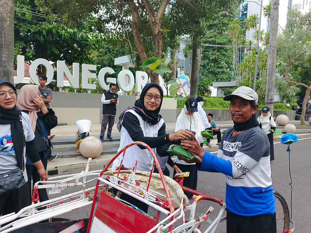 KAMPANYE JAGA LINGKUNGAN: Aktivis lingkungan bagikan bibit pohon kepada pengguna jalan, sebagai salah satu bentuk kampenye menjaga lingkungan. (YANA DWI KURNIYA WATI/RADAR BOJONEGORO)