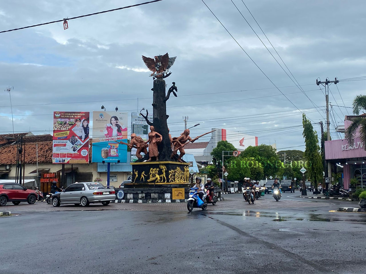 PERKOTAAN: Perempatan Jalan Tugu Pancasila Blora tampak basah usai diguyur hujan yang cukup deras. Tampak pengendara motor dan mobil ramai melintas. (M. LUKMAN HAKIM/RADAR BOJONEGORO)