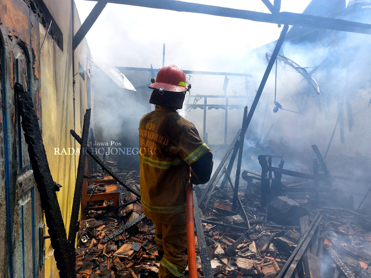 LUDES: Petugas damkar jinakkan api menghanguskan pabrik kerupuk di Desa Wantilgung turut Kecamatan Ngawen kemarin siang (2/5). (ISTIMEWA/RADAR BOJONEGORO)