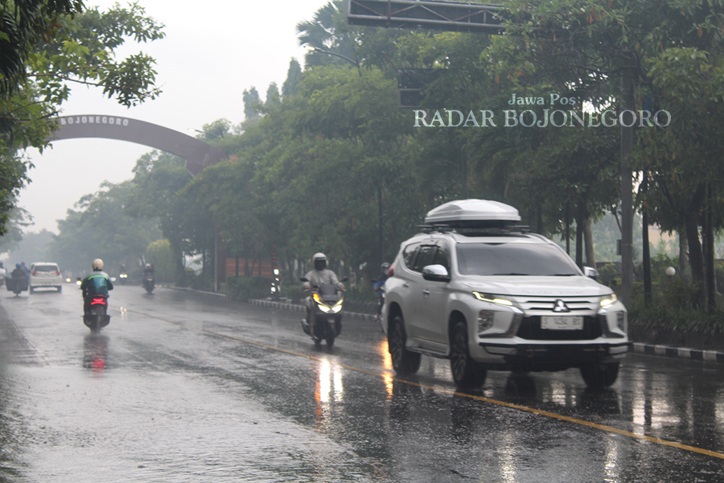 HUJAN: Tampak jalan Ahmad Yani basah dan pengendara motor mengenakan jas hujan. (DHANI WAHYU ALFIANSYAH/RADAR BOJONEGORO)