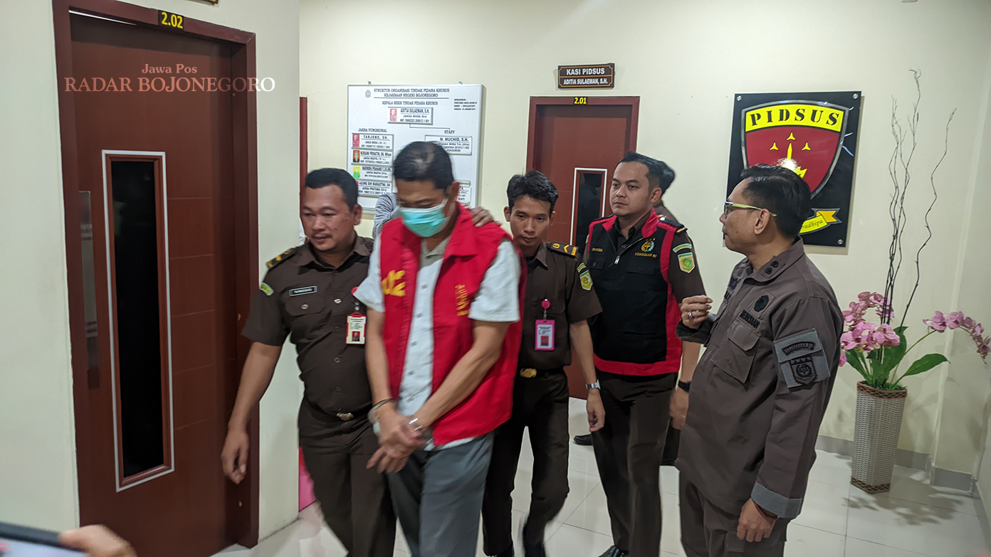 TERDAKWA: Salah satu terdakwa kasus dugaan korupsi mobil siaga yakni Indra Kusbianto digiring petugas Kejari Bojonegoro menuju mobil tahanan usai jalani pemeriksaan pada Agustus 2024 lalu. (DHANI WAHY