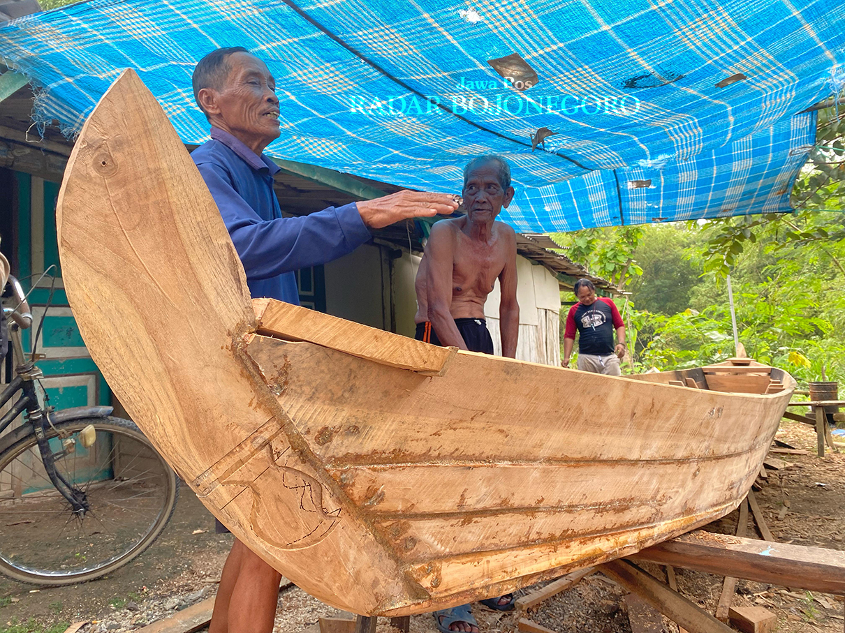 TETAP BERKARYA: Muhsin (kanan) perajin perahu yang masih eksis sejak 1955. (LUKMAN HAKIM/RADAR BOJONEGORO)