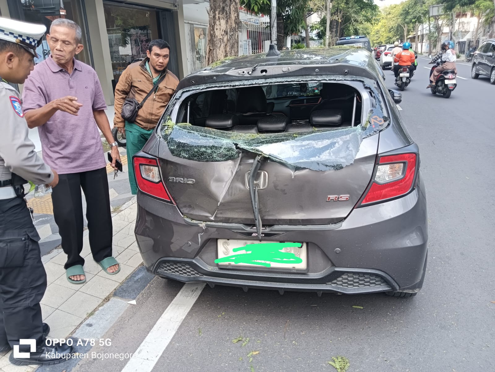 Kondisi bodi mobil milik pengendara penyok dan kacanya pecah.