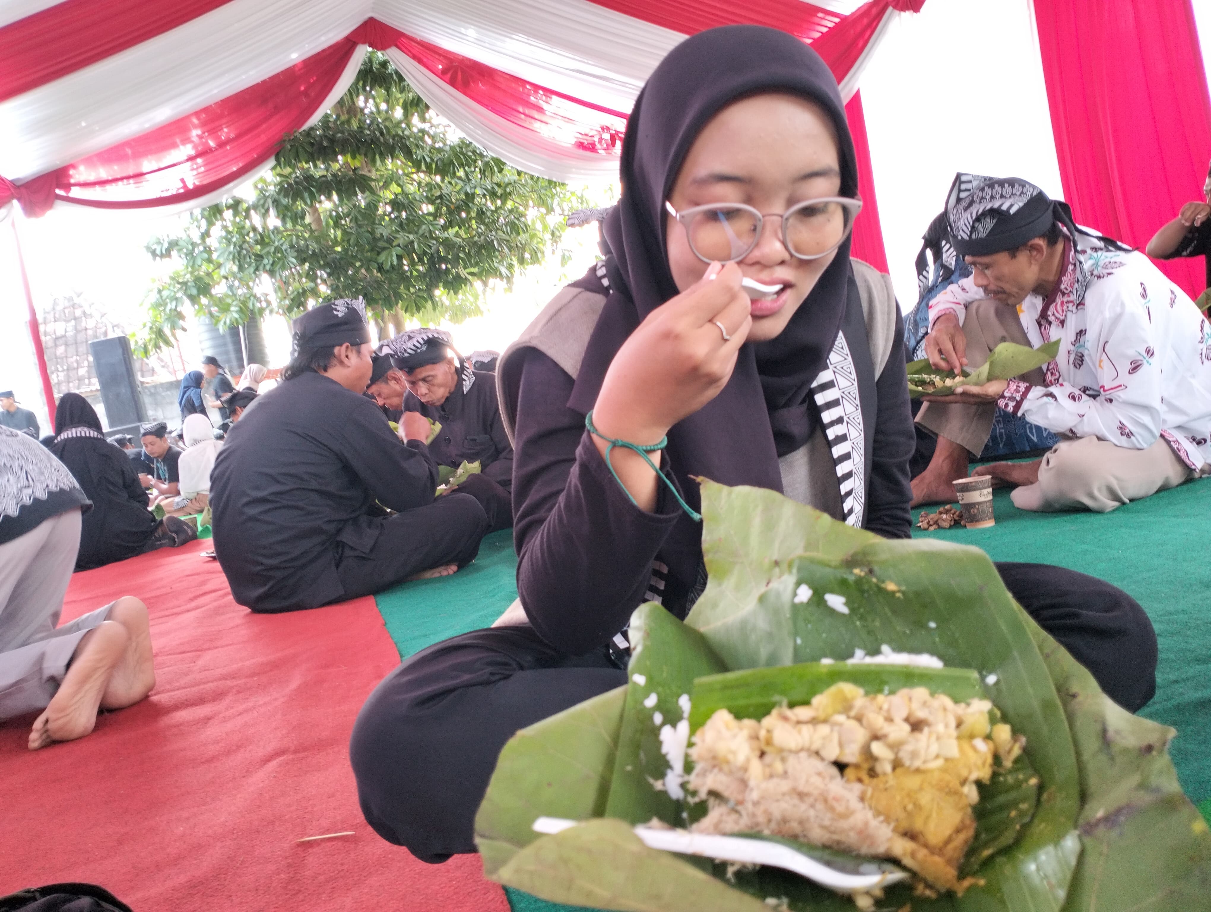 MENU KHAS : Salah satu warga menikmati nasi buwuhan khas Samin Bojonegoro.