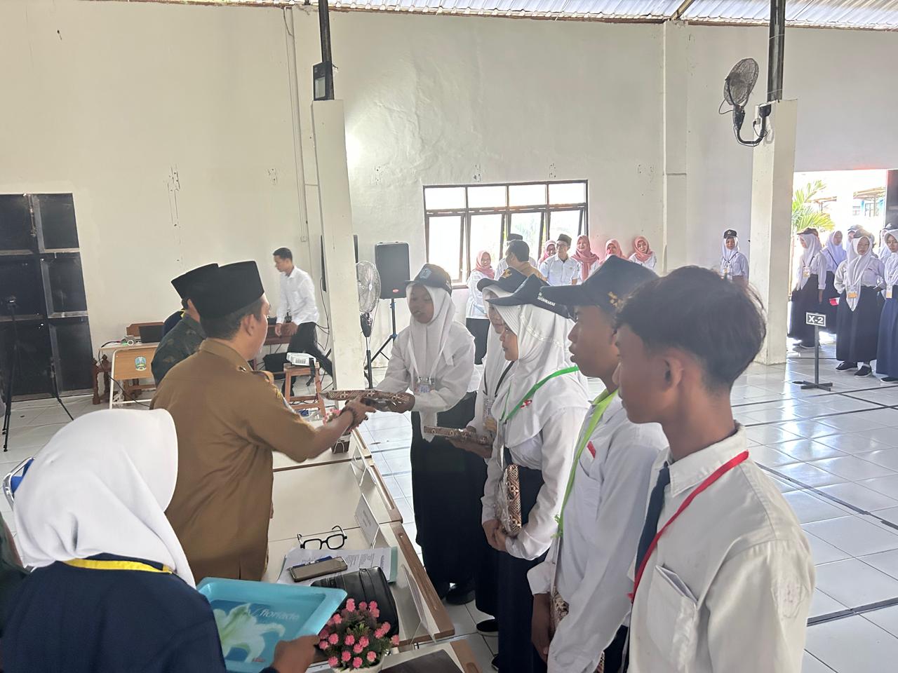 SANTUNAN : Kepala SMAN Sugihwaras memberikan santunan berupa seragam sekolah.