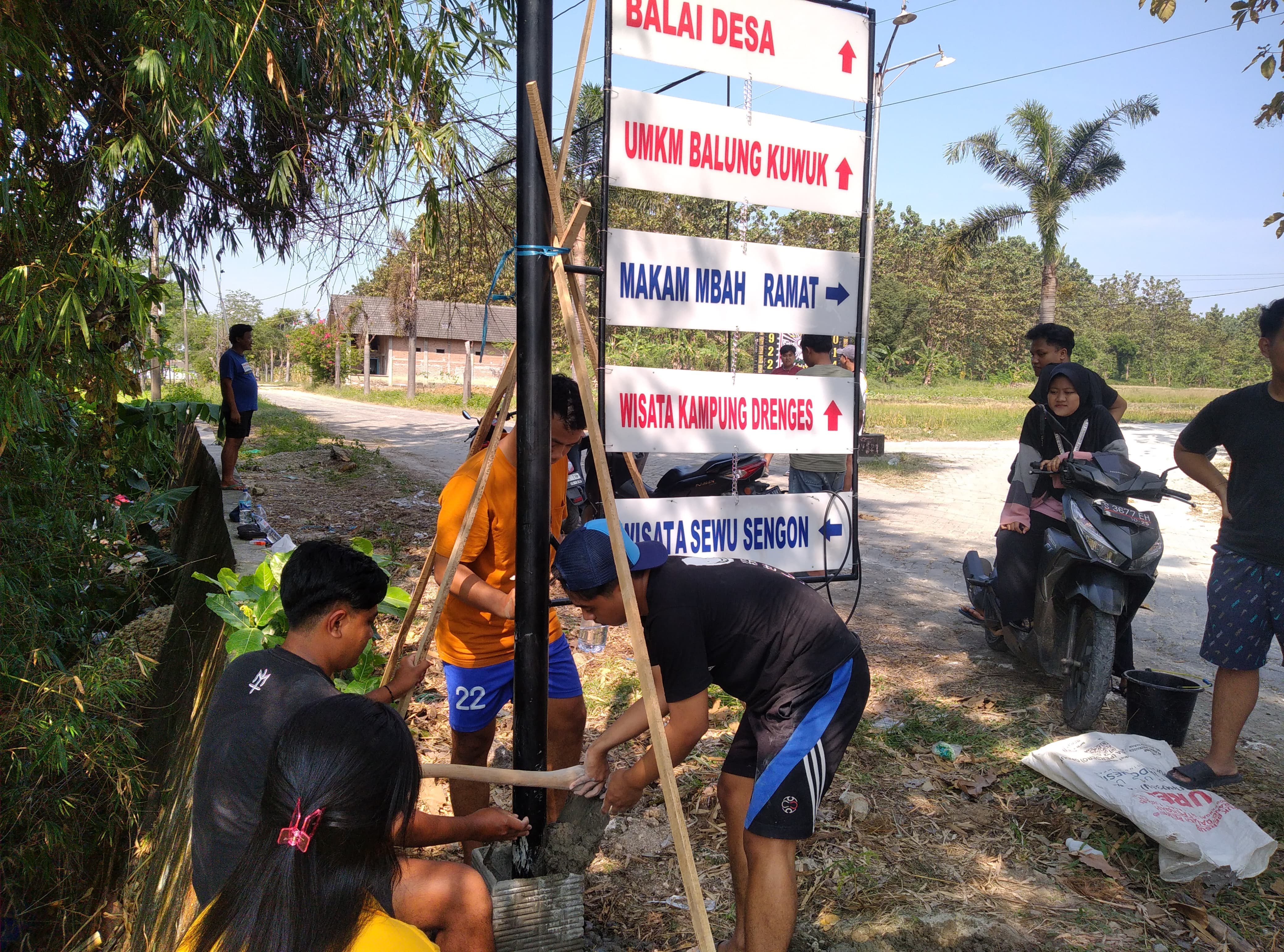 Para mahasiswa kelompok 22 KKN-TK Unigoro sedang memasang peta wisata di Desa Drenges, Kecamatan Sugihwaras, Bojonegoro.