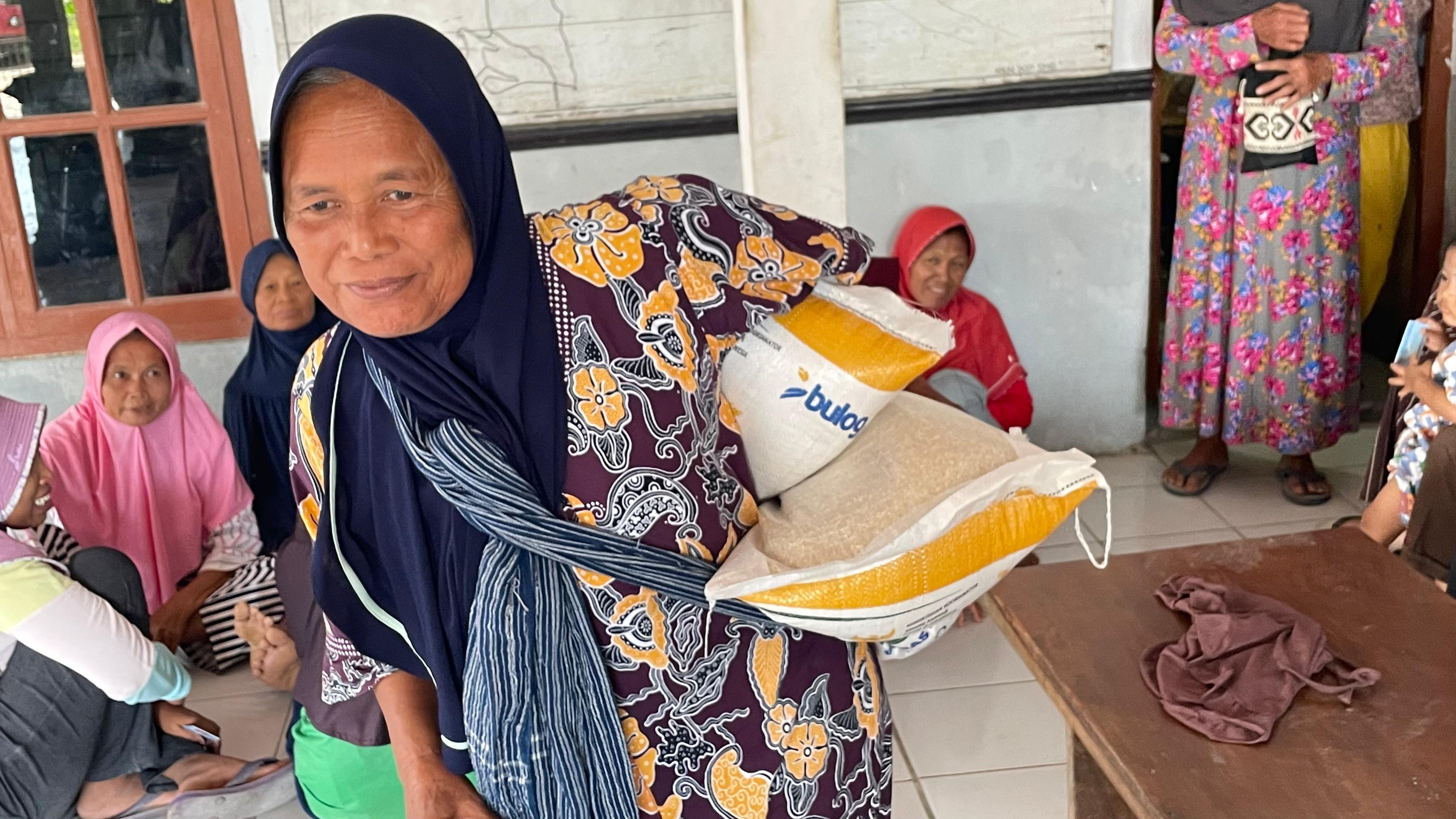 BANTUAN: Para warga tampak bersemangat mengambil bantuan beras sebanyak 20 kilogram di Balai Desa Genjahan, Kecamatan Jiken. (RAHUL OSCARRA DUTA/RADAR BOJONEGORO)