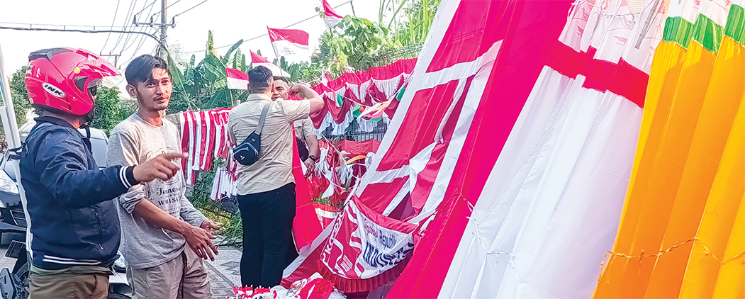 AGUSTUSAN: Ampi, seorang pedagang asal Kabupaten Garut setiap tahun jualah bendera merah putih di Bojonegoro. (DHANI WAHYU ALFIANSYAH/RADAR BOJONEGORO)