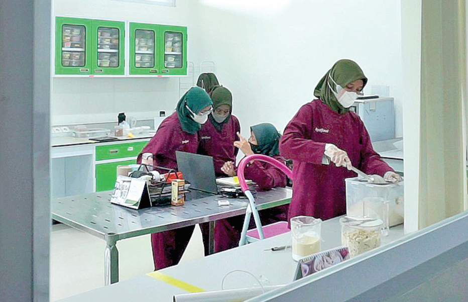 FOKUS: Para karyawan perempuan sedang fokus bekerja di dalam ruang laboratorium PT Realfood. (HAKAM ALGHIVARI/RADAR BOJONEGORO)