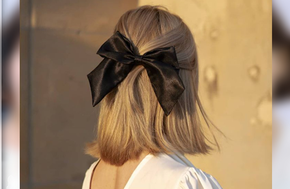 Potongan gaya rambut half up dengan ribbon.