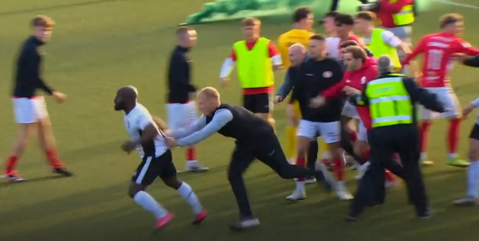 Fuad Sule (Dua dari kiri) ditahan oleh staf Glentoran setelah berkelahi dengan pemain Larne, dan mengincar staf mereka. (Dok. BBC)