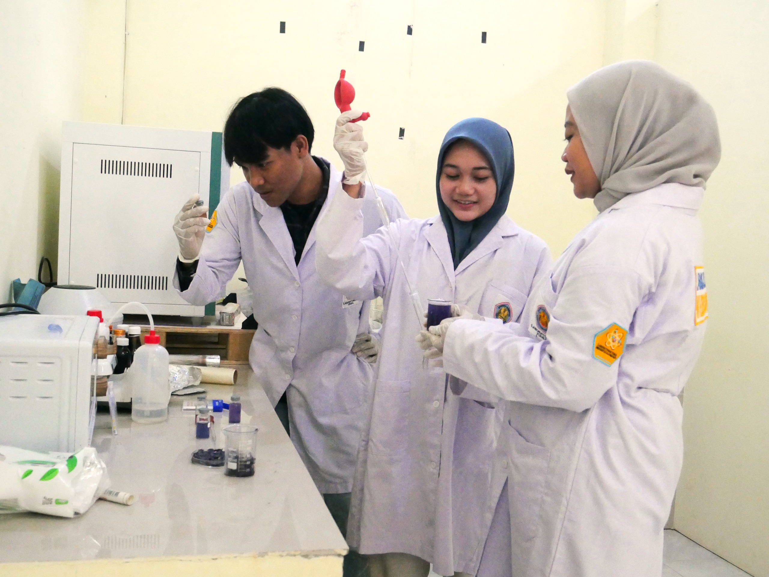 Tita Zakiyya Ghozali (tengah) bersama tim Program Kreativitas Mahasiswa (PKM) 2024 di laboratorium Kimia Fakultas Sains dan Teknik Unigoro.