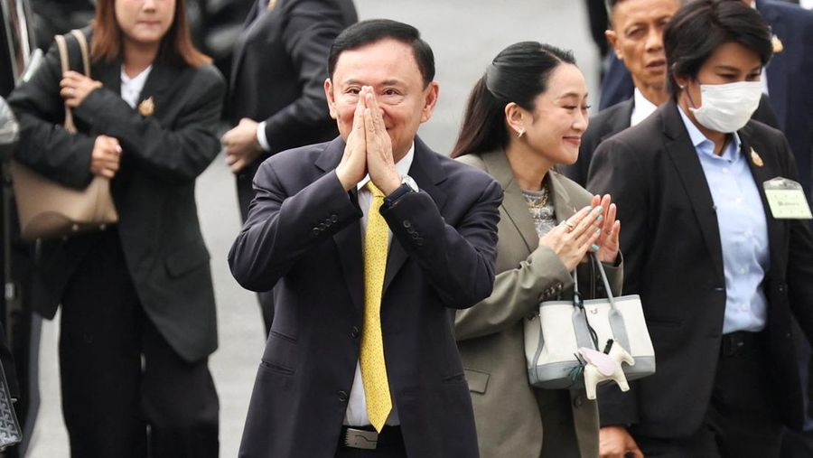 Mantan PM Thailand Thaksin Shinawatra (dasi kuning) menyapa masyarakat sebelum menghadiri pengadilan Mahkamah Agung Thailand. (Dok. Reuters)