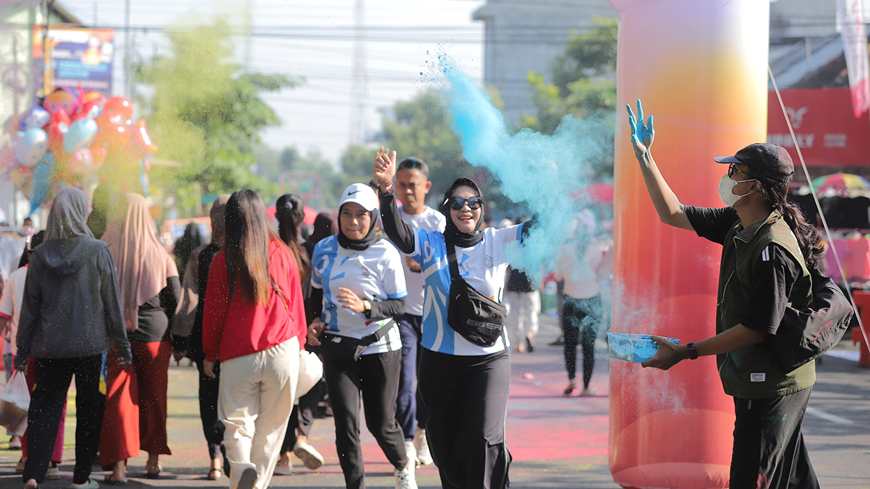 WARNA-WARNI: Salah satu peserta Apothecolor Walk 2025 tampak semringah saat masuk garis finish.