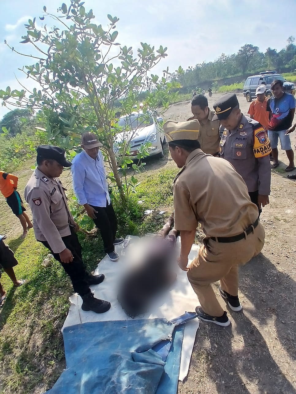 EVAKUASI: Petugas kepolisian mengevakuasi korban tewas tersengat jebakan tikus di sawah turut Desa Katur, Kecamatan Gayam, Bojonegoro.