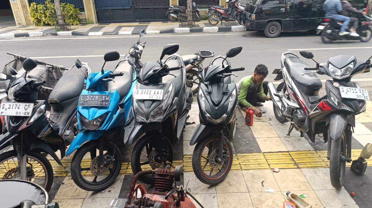 MOGOK MASAL: Salah satu mekanik  di bengkel Jalan Basuki Rahmat Bojonegoro kebanjiran order setelah terjadi motor mogok masal, dengan keluhan sama, mesin sulit hidup.