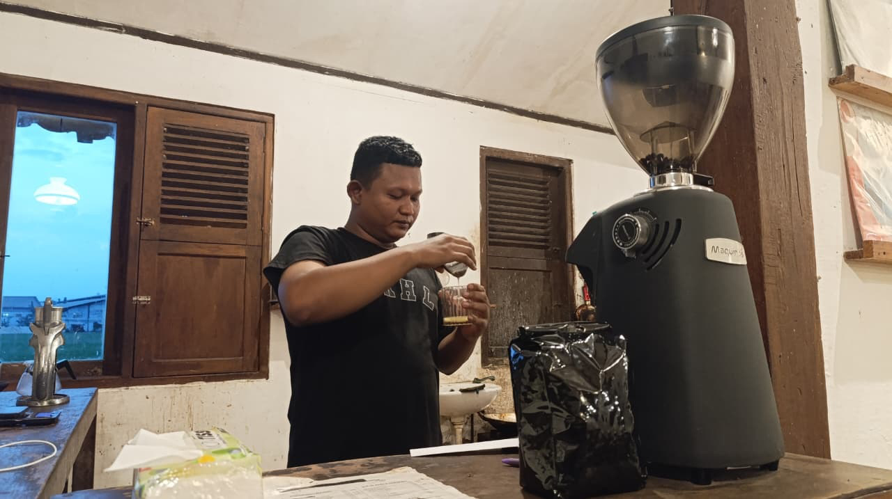 FOKUS: Seorang barista sedang fokus meracik kopi menggunakan mesin espresso di salah satu kedai kopi turut Jalan Pondok Pinang, Desa Sukorejo, Kecamatan Bojonegoro Kota.