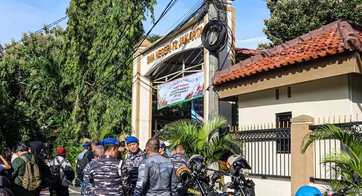 Sehari setelah insiden pengeboman di masjid SMAN 72 Jakarta, Polisi Polda Metro Jaya dan Polisi Militer TNI AL menjaga bersama-sama komplek sekolah tersebut. (Hanung Hambara/ Jawa Pos)