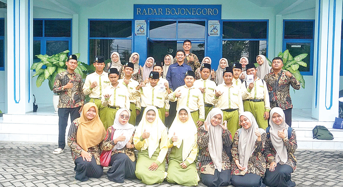 BELAJAR: Rombongan siswa dan guru MTs Plus Al Fatimah foto bersama di teras halaman kantor Radar Bojonegoro usai belajar seputar jurnalistik.
