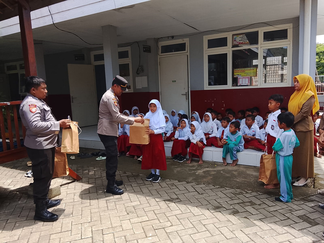 DUKUNG SEMANGAT BELAJAR: Polres Bojonegoro menyerahkan sepatu kepada para siswa SDN Bobol III, Kecamatan Sekar, Selasa (18/11).