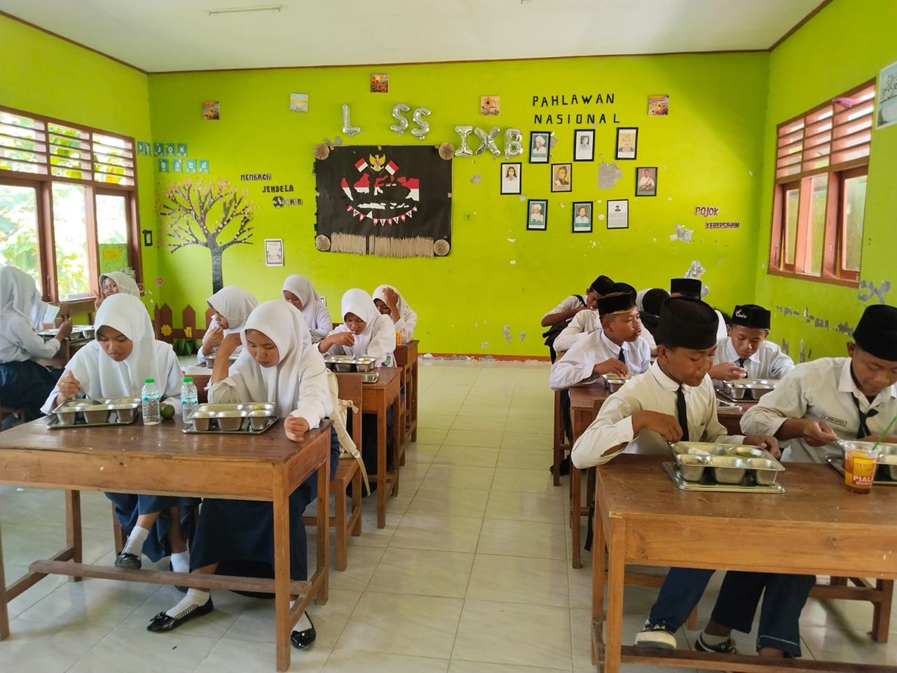MAKAN SIANG: Siswa sedang menikmati makanan bergizi yang dibiayai dari uang negara.