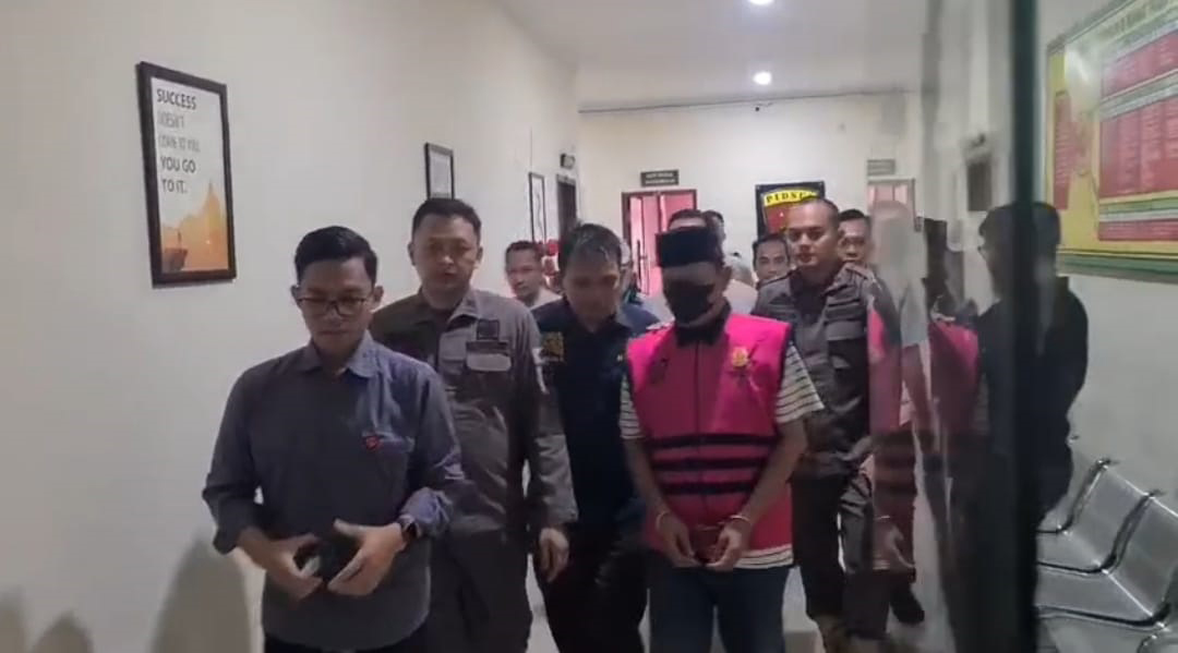 DIBUI: Eks Kasatpol PP Heru Sugiarto, tersangka dugaan korupsi BKKD Padangan 2021 digiring petugas Kejari Bojonegoro menuju mobil tahanan Kamis (27/11).