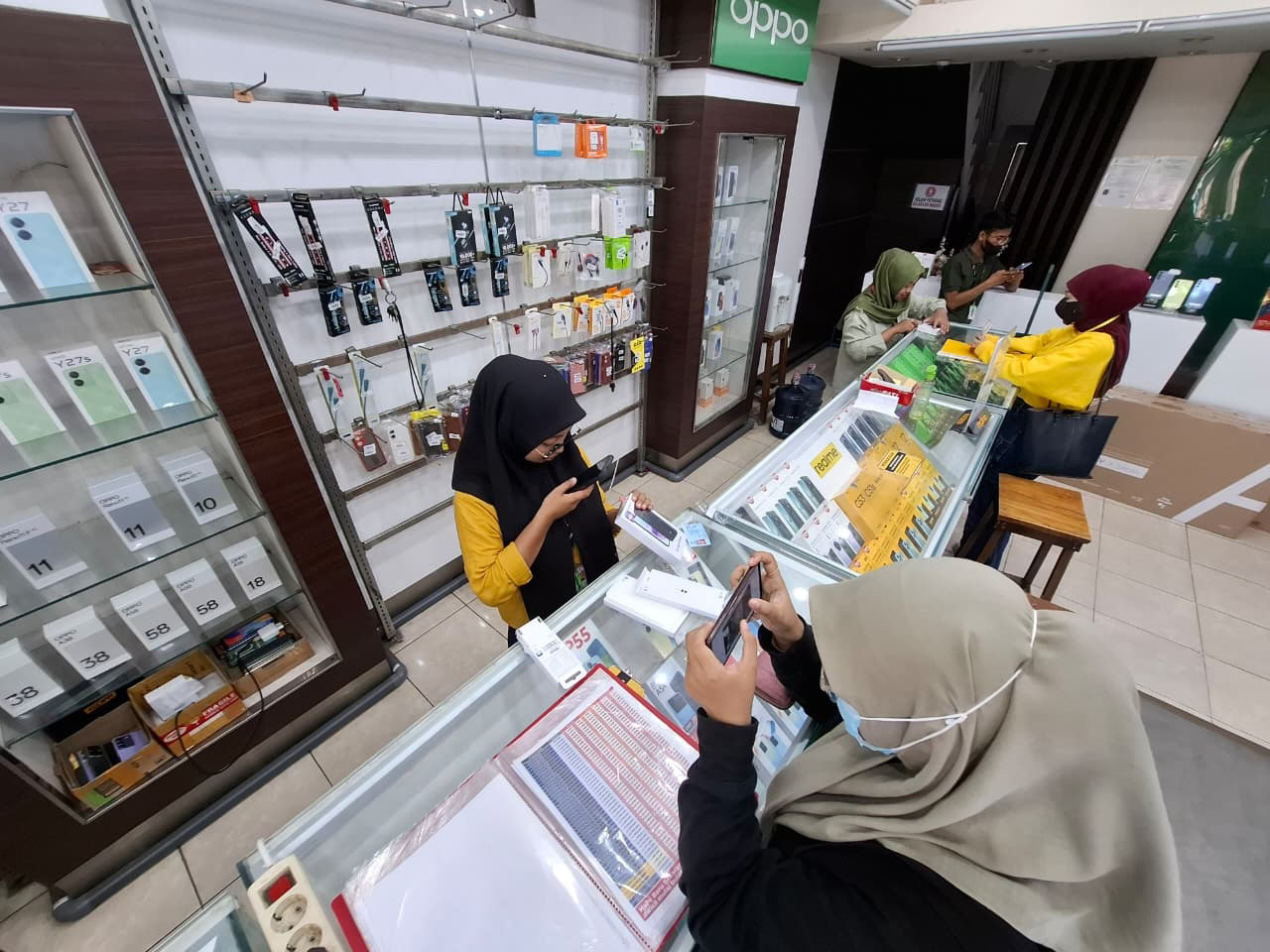 KARYAWAN: Pekerja salah tuku toko ponsel di Bojonegoro Kota tengah melayani pembeli.