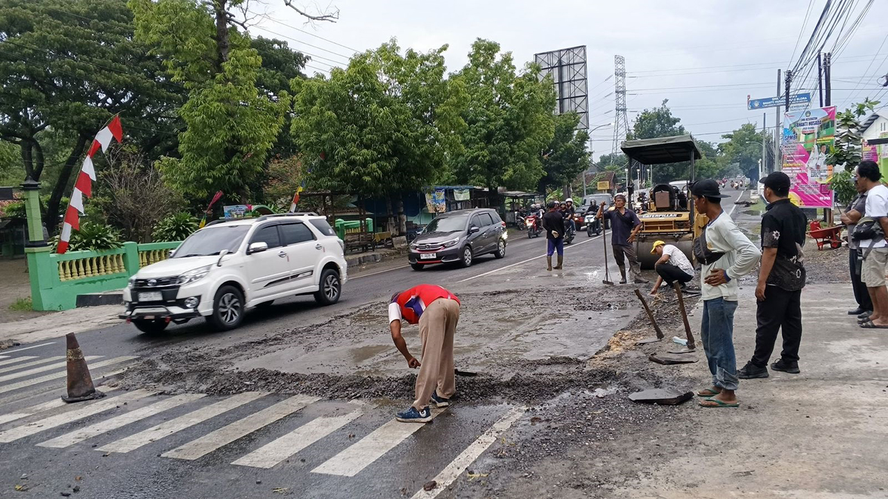 JALUR PENGHUBUNG: Pekerja lapangan mulai menambal titik Jalan Provinsi yang berlubang.