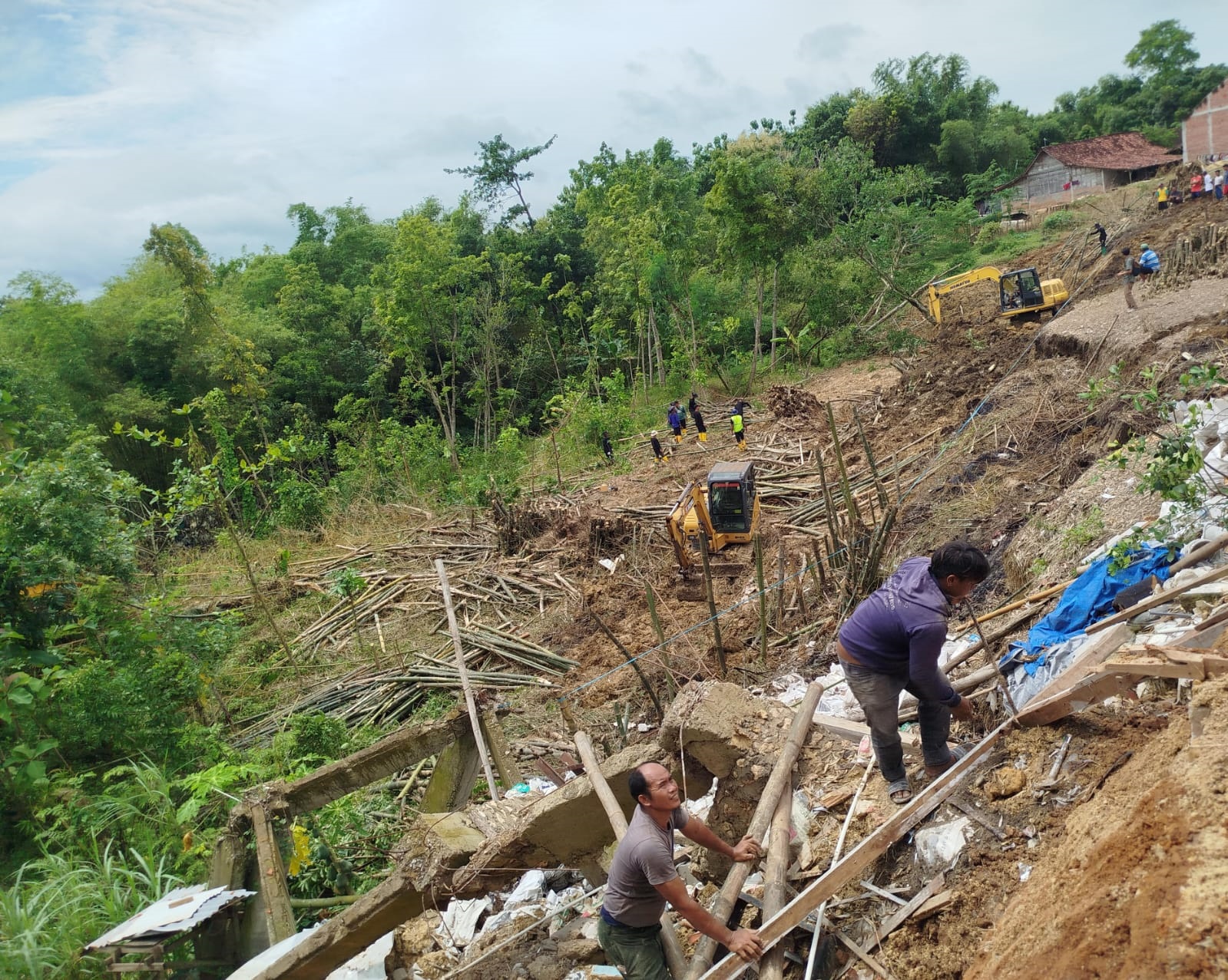 BUTUH PENANGANAN: Kondisi akses jalan Dusun Ngetrep, Desa Tutup, Kecamatan Tunjungan yang longsor. Tampak sejumlah warga melintas dengan jalan kaki melintas di sana.