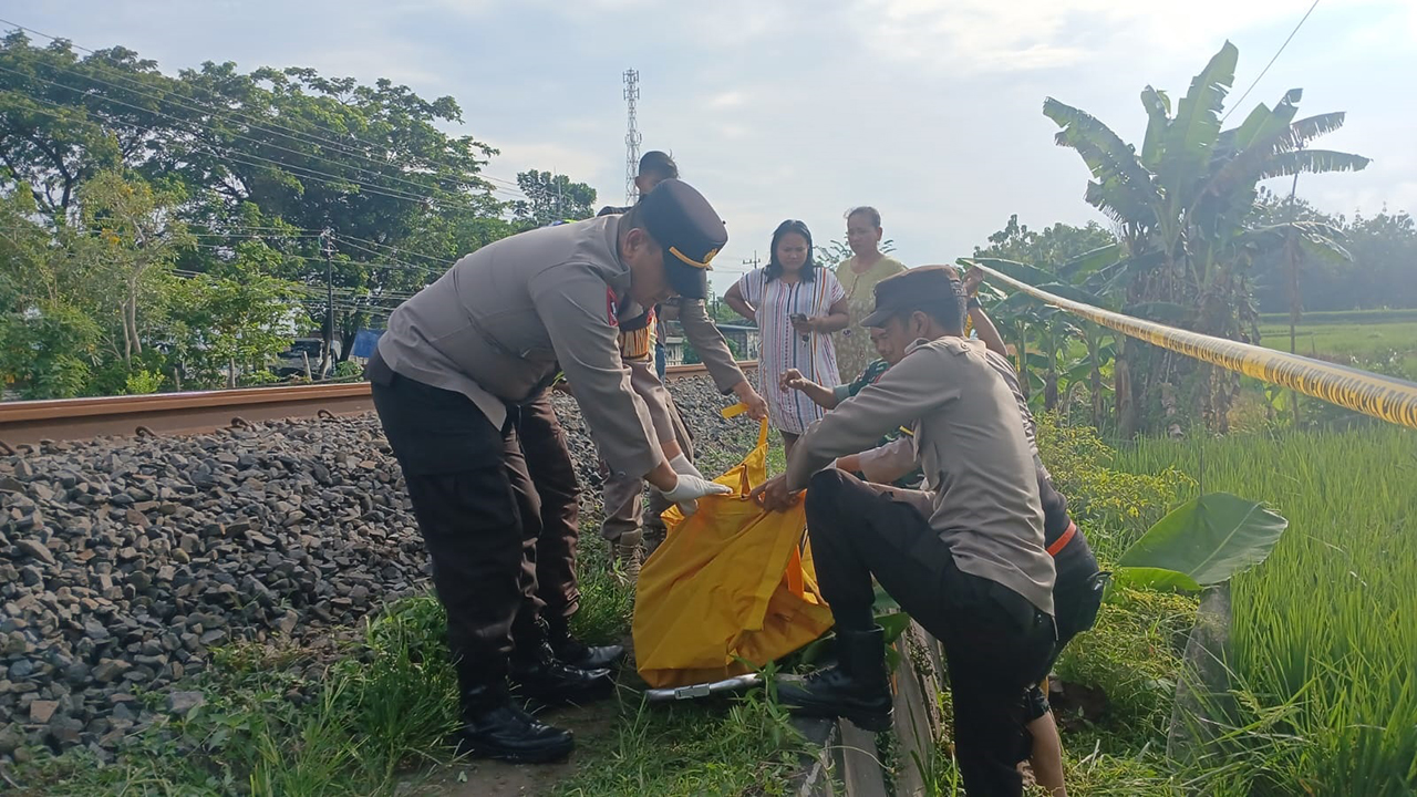 EVAKUASI: Petugas mengevakuasi korban kecelakaan KA di Desa Talok, Kecamatan Kalitidu kemarin.