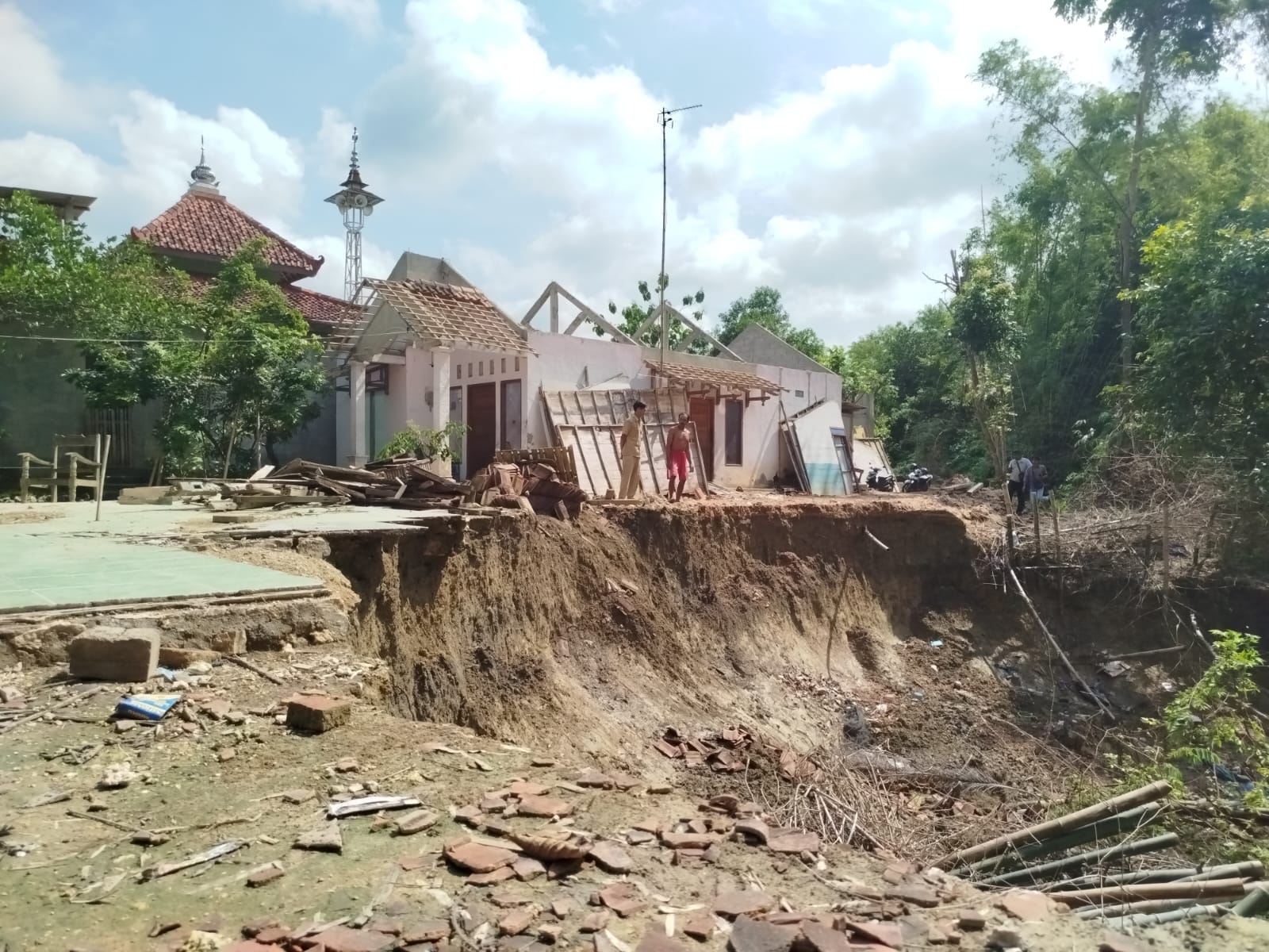 BUTUH PENANGANAN CEPAT: Warga Dukuh lukbang, Desa Puledagel, Kecamatan Jepon menunjukkan titik longsor yang makin parah ketika diguyur hujan deras.