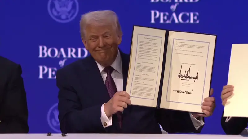 Presiden AS Donald Trump menampilakn piagam peresmian pembentukan Badan Perdamaian (BoP) dalam World Economic Forum pada Kamis (22/1). (Dok. Reuters)