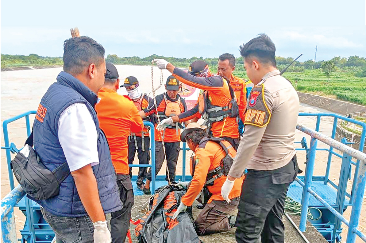 LAKUKAN EVAKUASI: Petugas gabungan mengevakuasi jasad Gami, korban tenggelam di DAS Bengawan Solo
