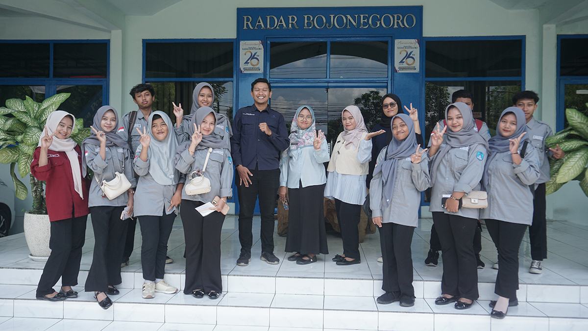 SALAM LITERASI: Siswa SMKN 4 foto bersama dengan tim Redaksi Radar Bojonegoro Bhagas Dani Purwoko dan Yana Dwi Kurniya Wati setelah menerima materi jurnalistik.