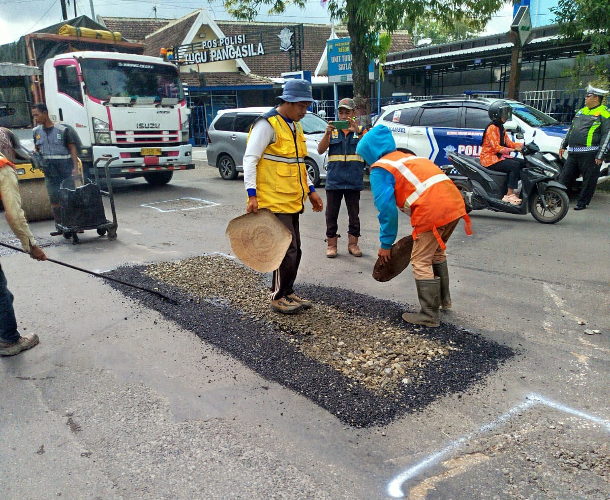 PENGERJAAN RUTIN: Petugas melakukan tambal sulam di Jalan Gunandar.