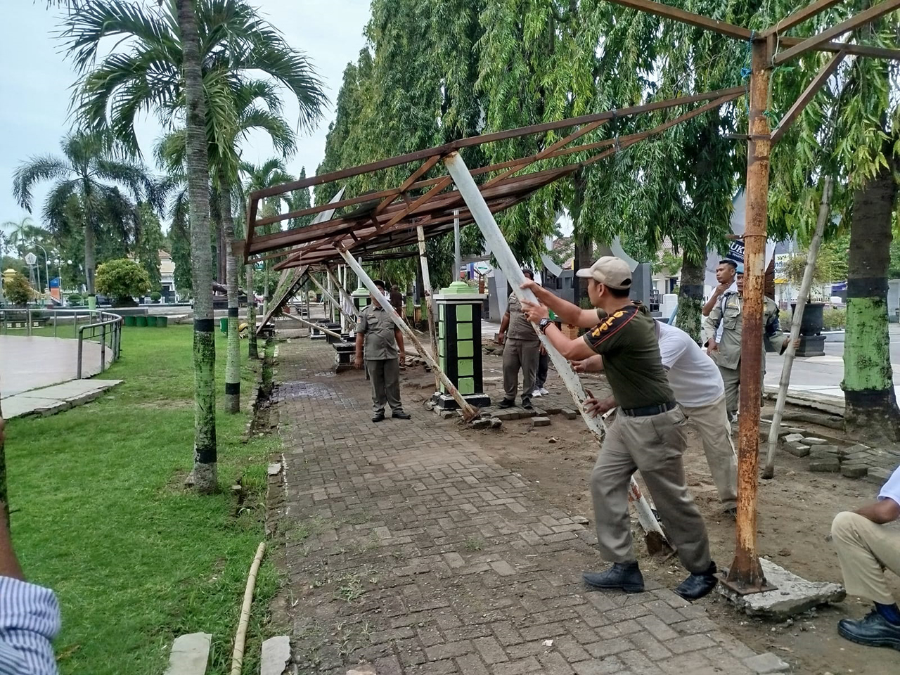 MENGEMBALIKAN FUNGSI: Petugas Satpol PP melakukan pembongkaran 12 lapak di area Alun-Alun Blora sebagai tempat pedagang angkringan. 